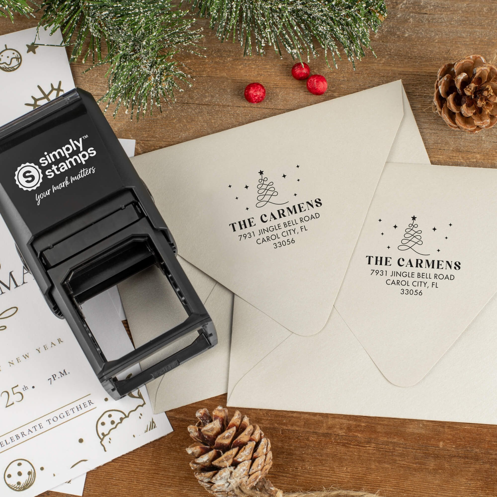 Holiday-themed ‘Modern Christmas Tree’ address stamp shown on envelopes beside festive stationery, pinecones, and decorations.