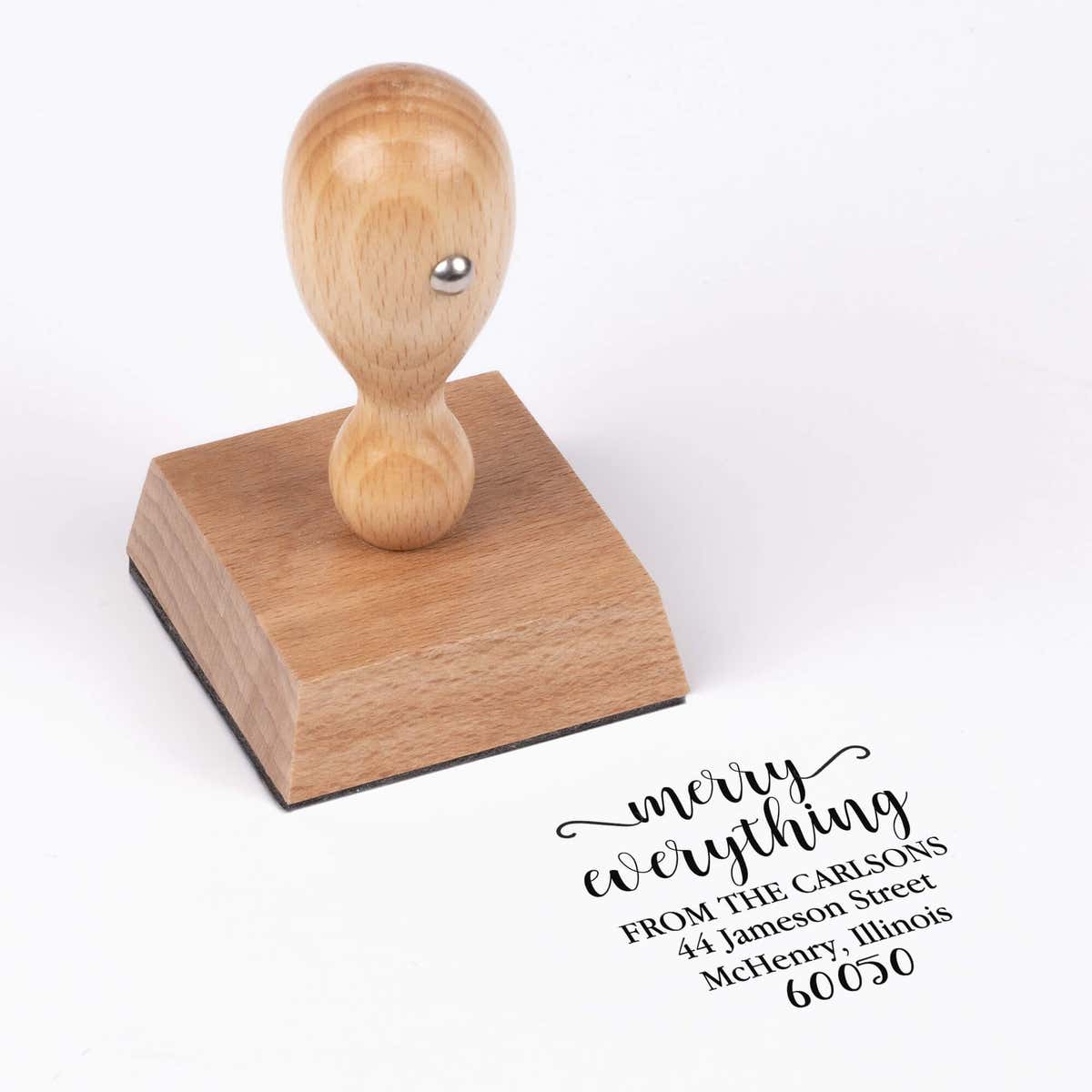 European wood hand stamp shown from above featuring custom ‘Merry Everything’ holiday return address design.