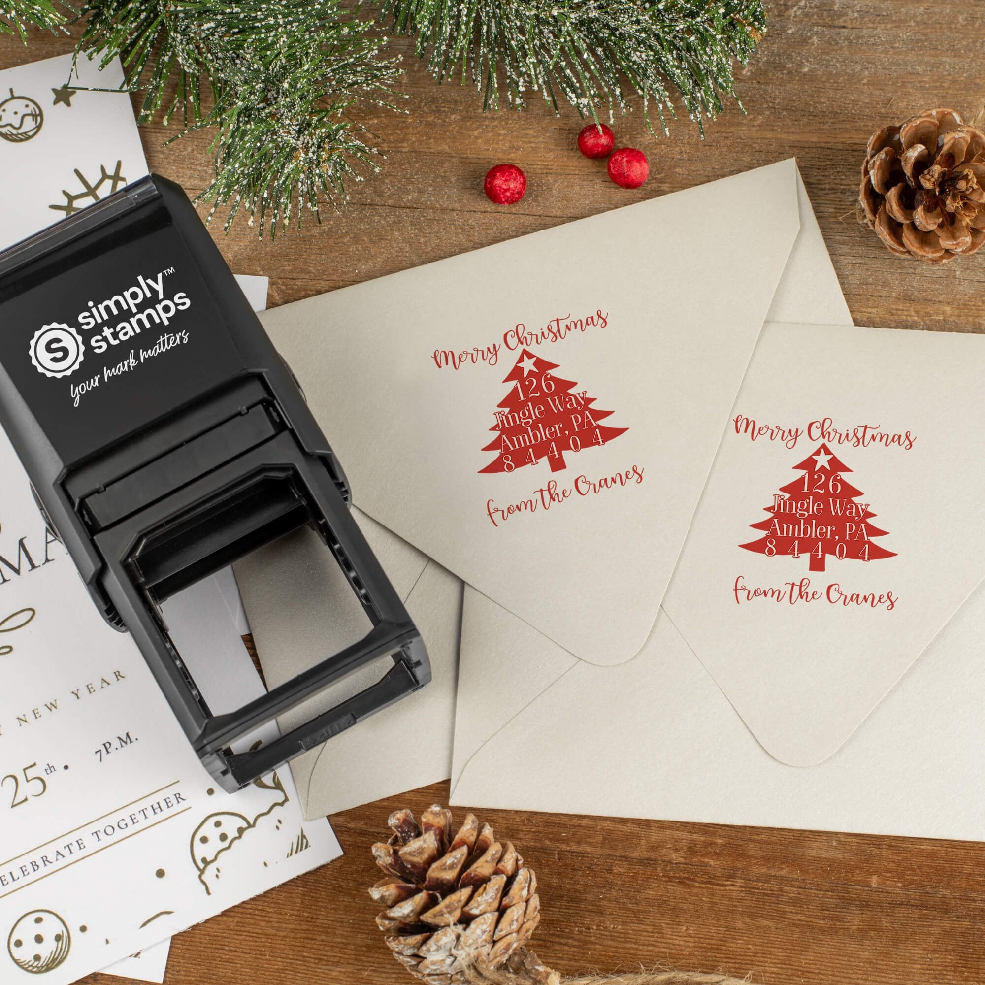 Holiday-themed ‘Christmas Tree’ address stamp shown on envelopes beside festive stationery, pinecones, and decorations.