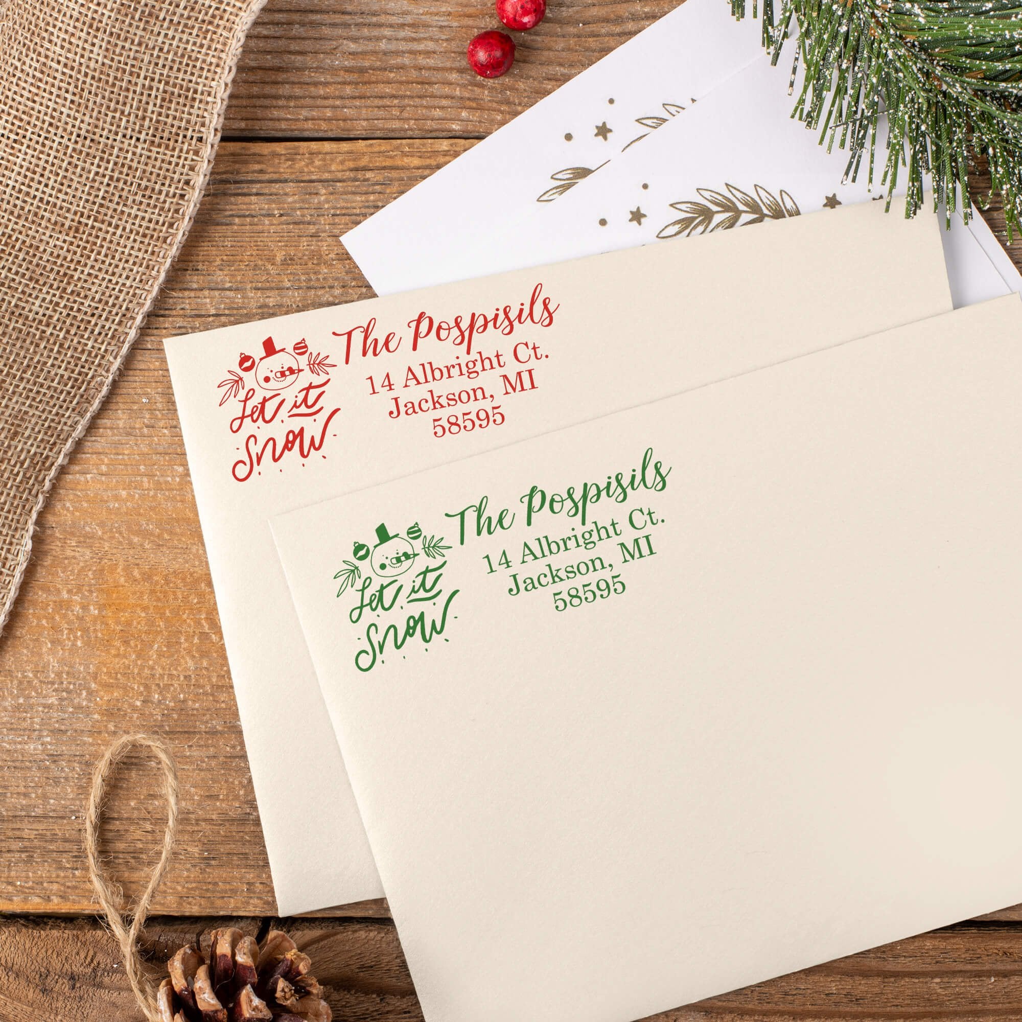 Green and red ink impressions of ‘Let It Snow Winter Snowman’ return address stamp on Christmas envelopes.