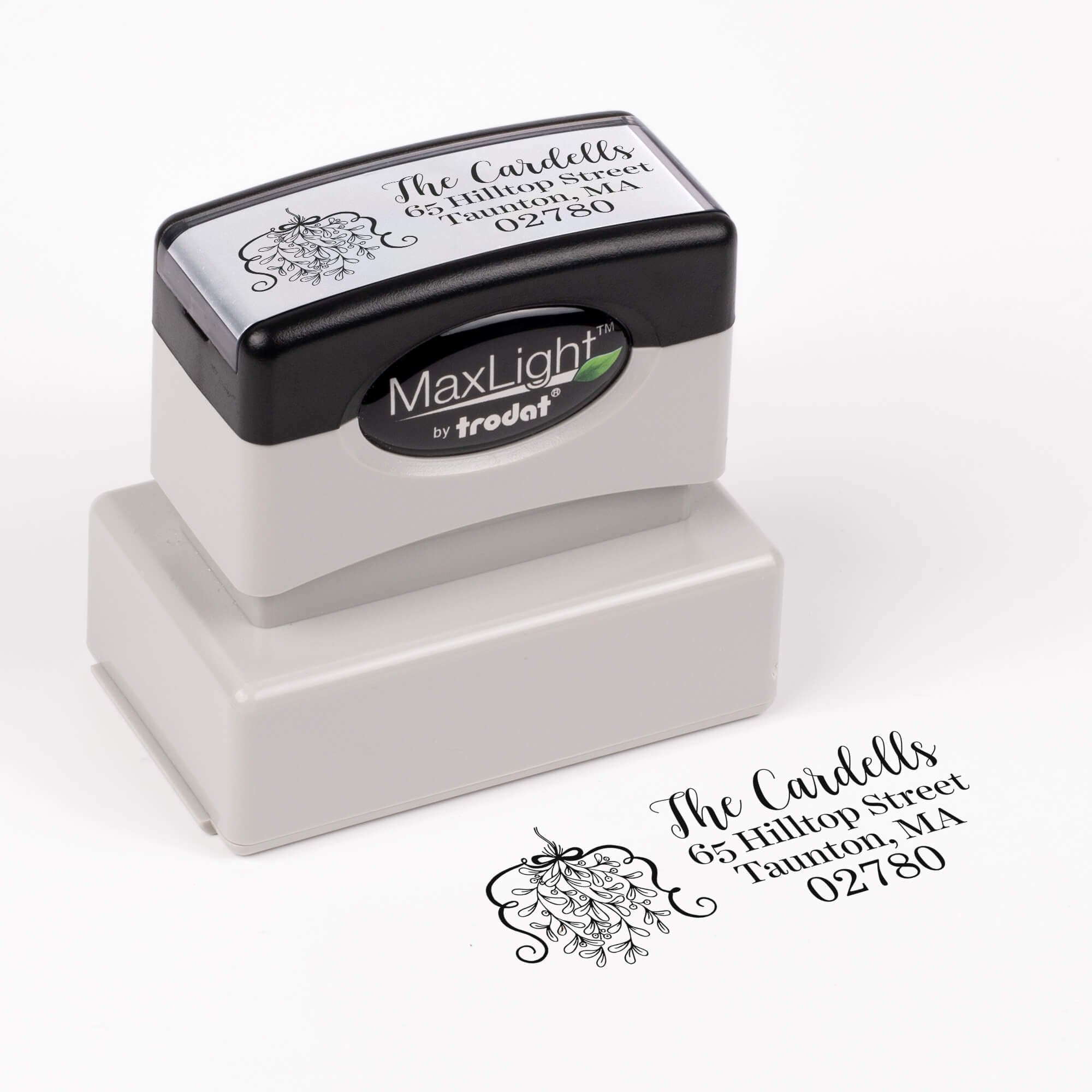 Pre-inked stamp shown from above featuring custom ‘Curly Mistletoe Holiday’  holiday return address design.