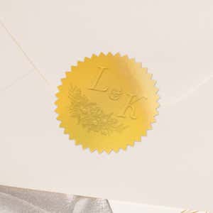 Close-up of gold foil seal with embossed design impression on the back of an envelope 