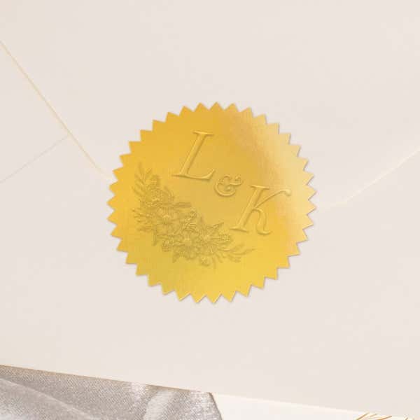 Close-up of gold foil seal with embossed design impression on the back of an envelope 