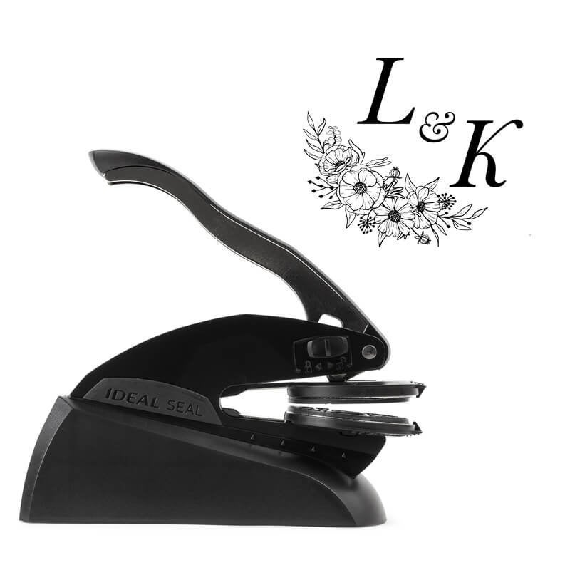 Professional black embosser shown beside a sample impression of a wedding design