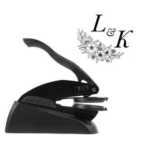 Professional black embosser shown beside a sample impression of a wedding design
