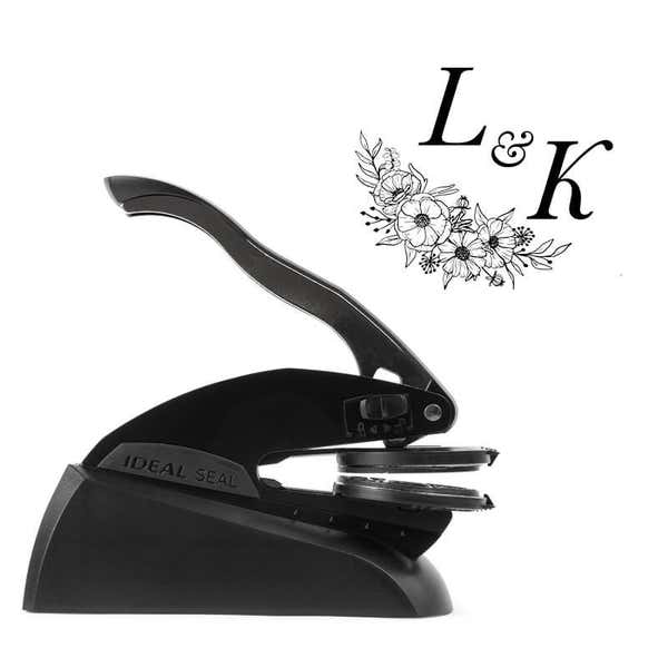 Professional black embosser shown beside a sample impression of a wedding design