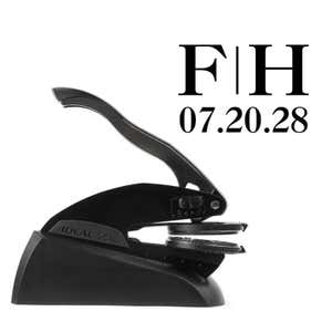 Professional black embosser shown beside a sample impression of the wedding design
