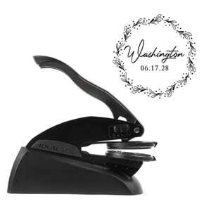 Professional black embosser shown beside a sample impression print