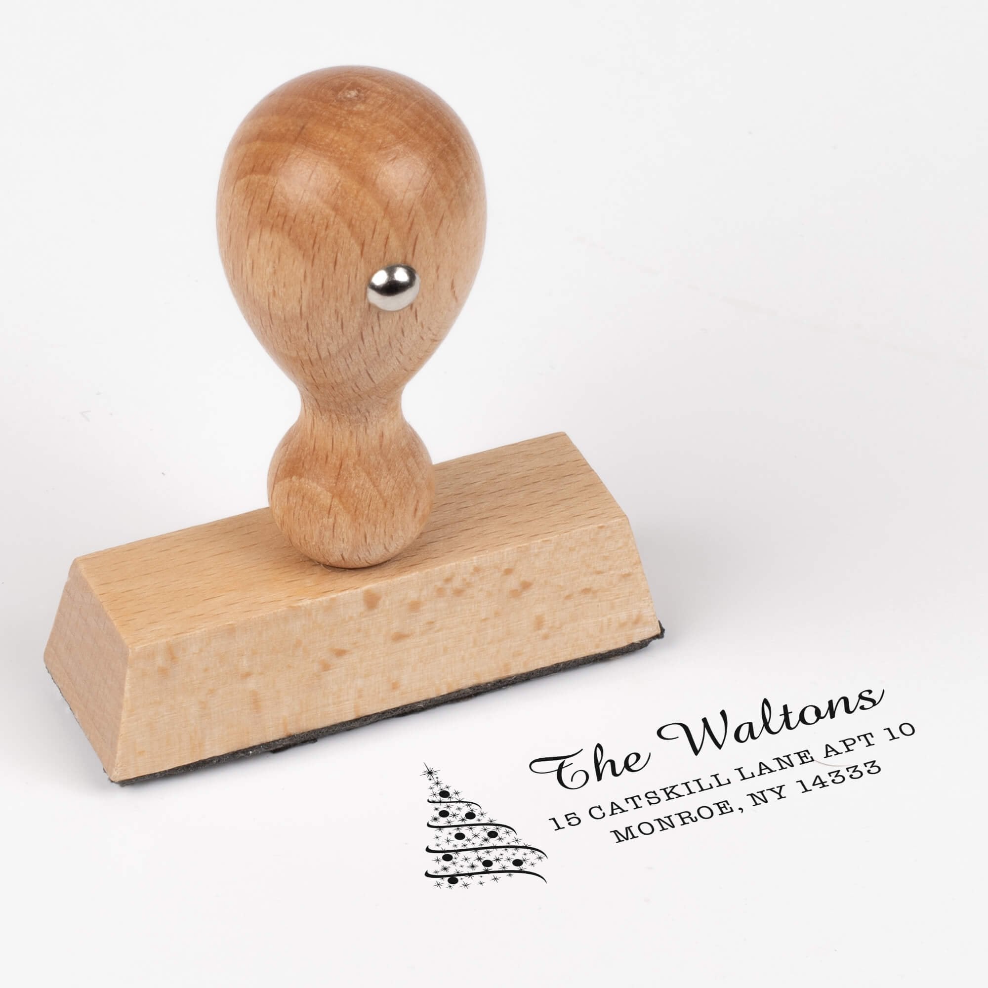 European wood hand stamp shown from above featuring custom ‘Walton Christmas Tree’ holiday return address design.