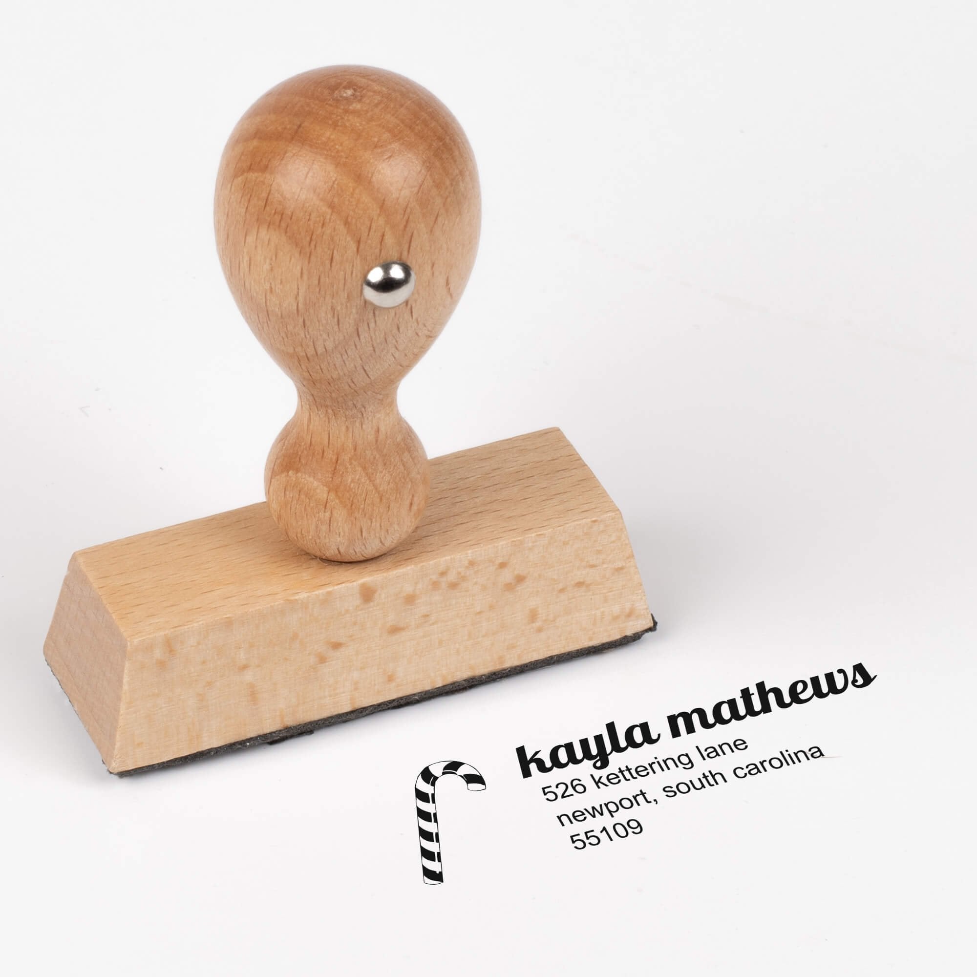 European wood hand stamp shown from above featuring custom ‘Mathews Candy Cane’ holiday return address design.