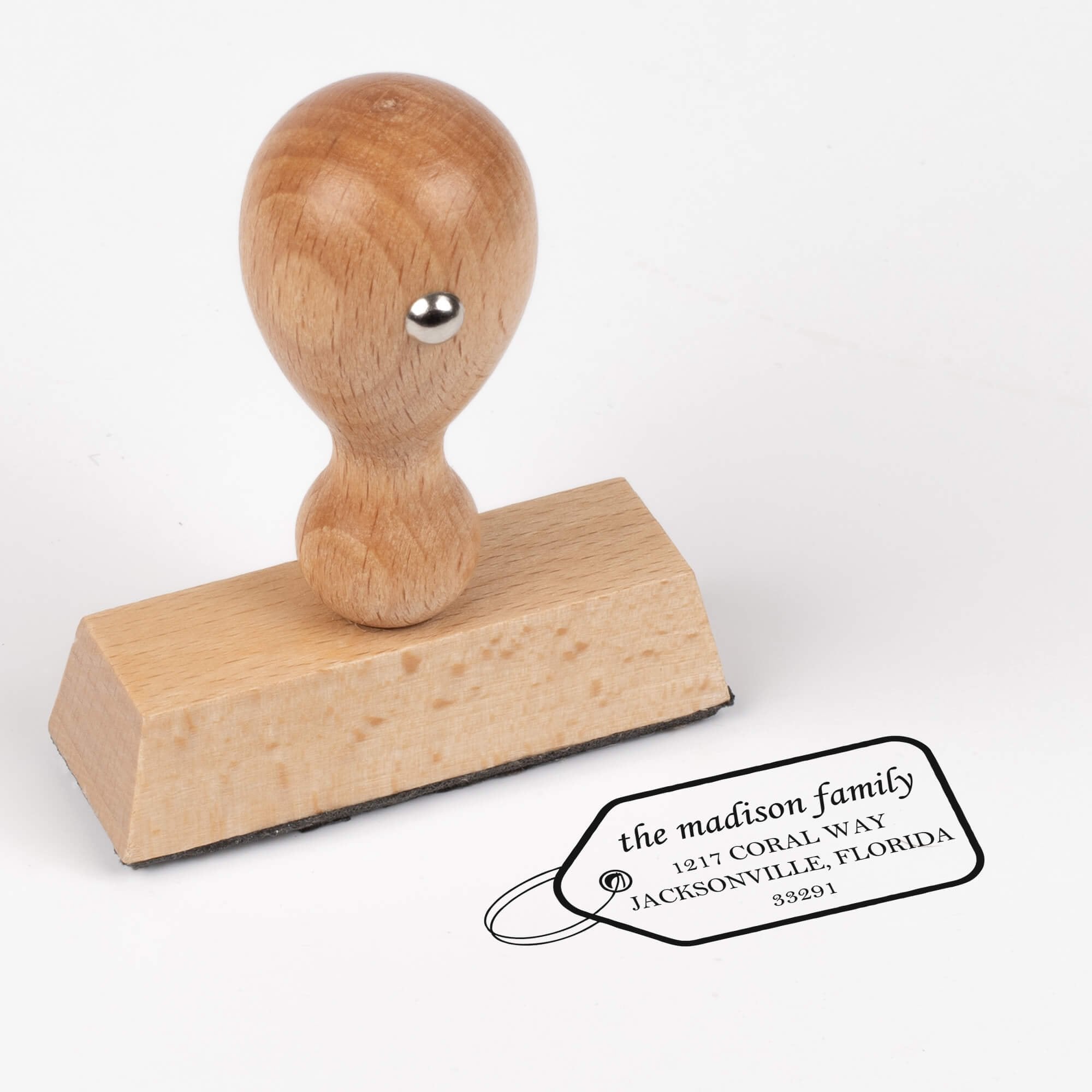 European wood hand stamp shown from above featuring custom ‘Madison Gift Tag’ holiday return address design.