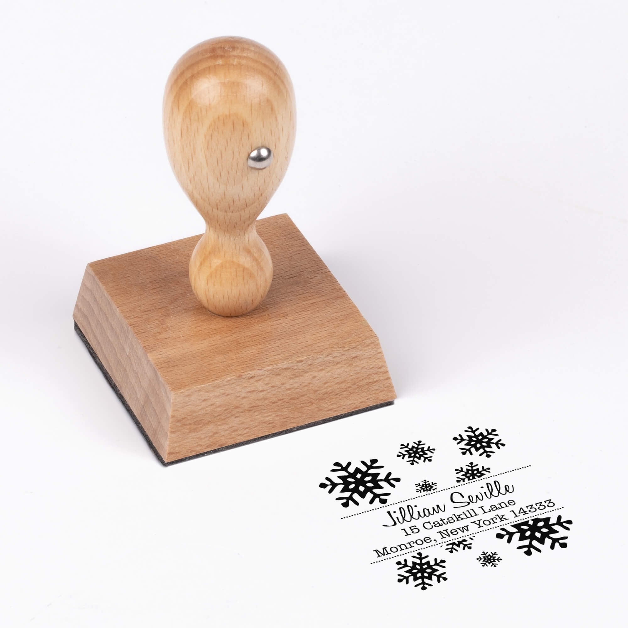 European wood hand stamp shown from above featuring custom ‘Seville Snowflakes’ holiday return address design.
