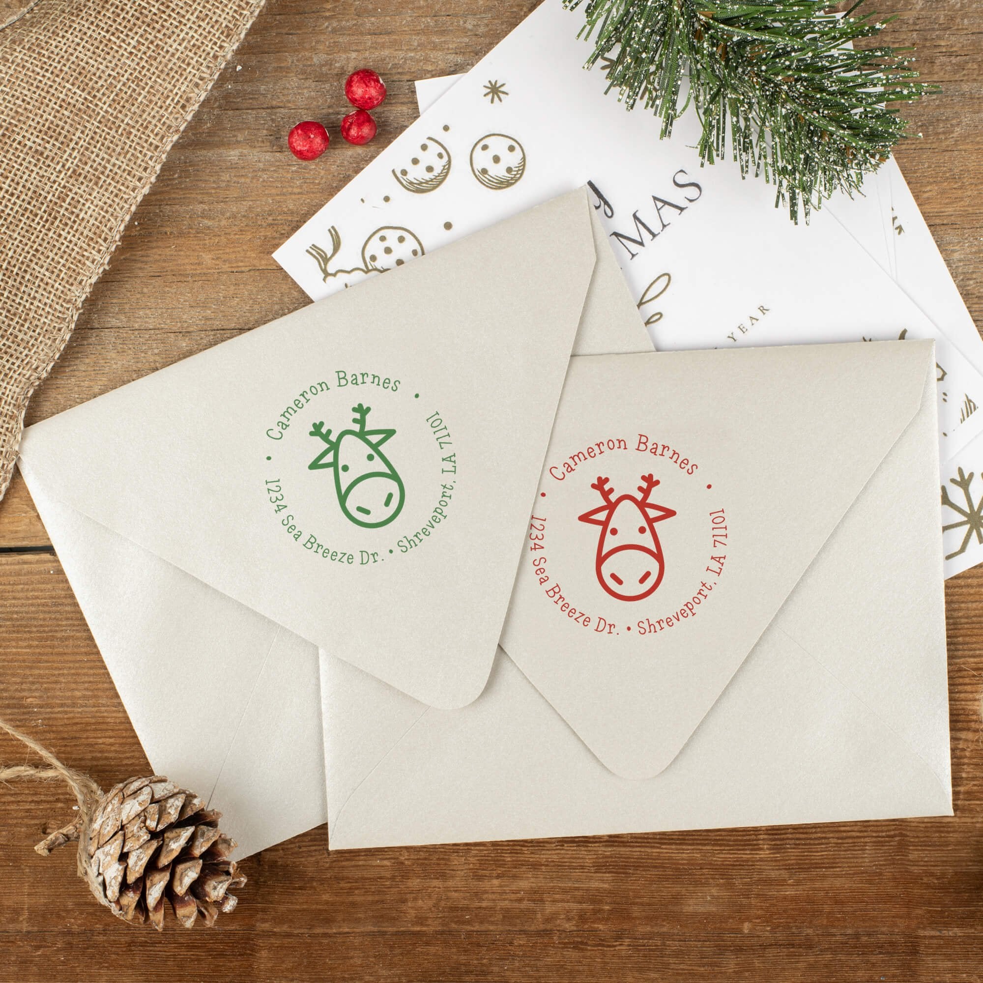 Green and red ink impressions of ‘Geometric Reindeer’ return address stamp on Christmas envelopes.