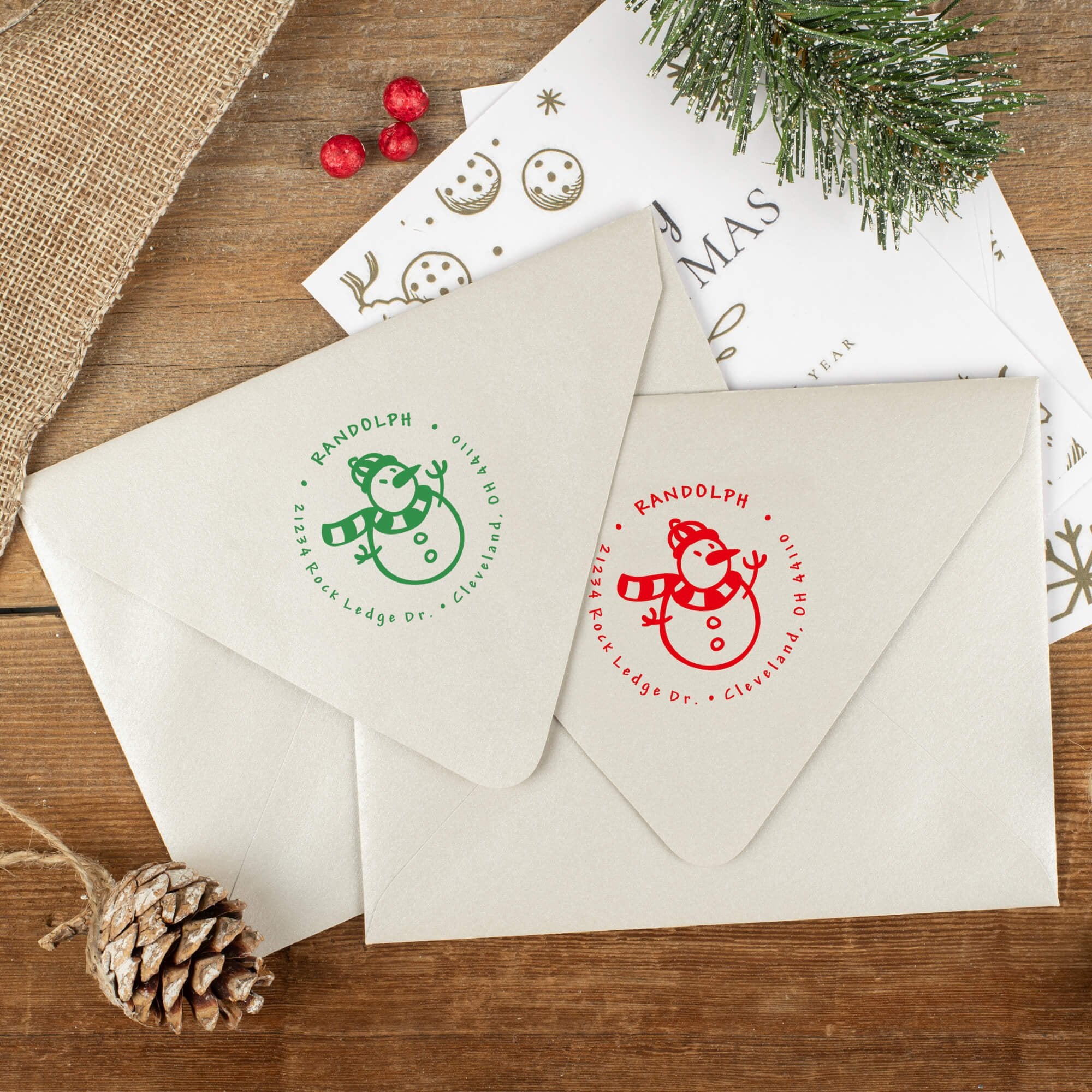 Green and red ink impressions of ‘Scarved Snowman’ return address stamp on Christmas envelopes.