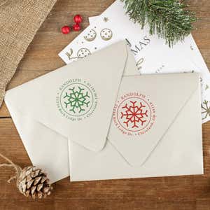 Green and red ink impressions of ‘Eight Point Snowflake’ return address stamp on Christmas envelopes.