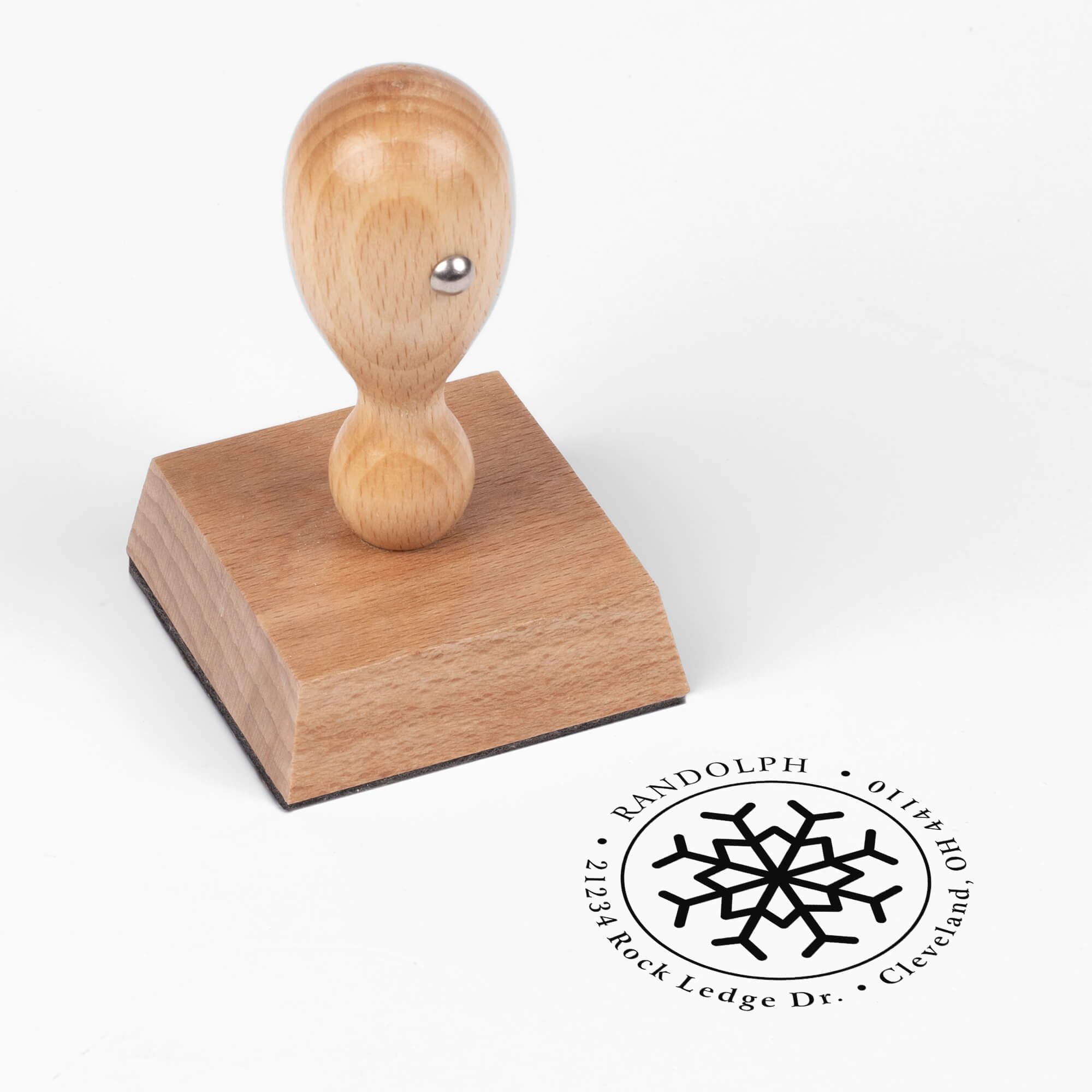 European wood hand stamp shown from above featuring custom ‘Eight Point Snowflake’ holiday return address design.
