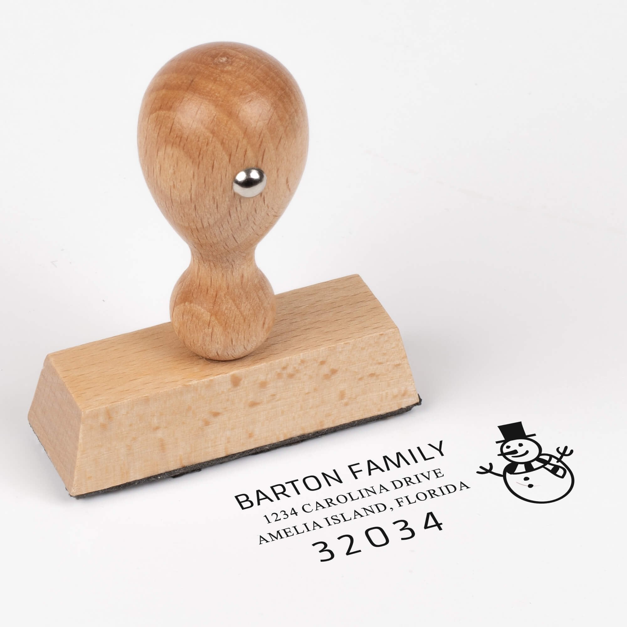European wood hand stamp shown from above featuring custom ‘Snowman’ holiday return address design.
