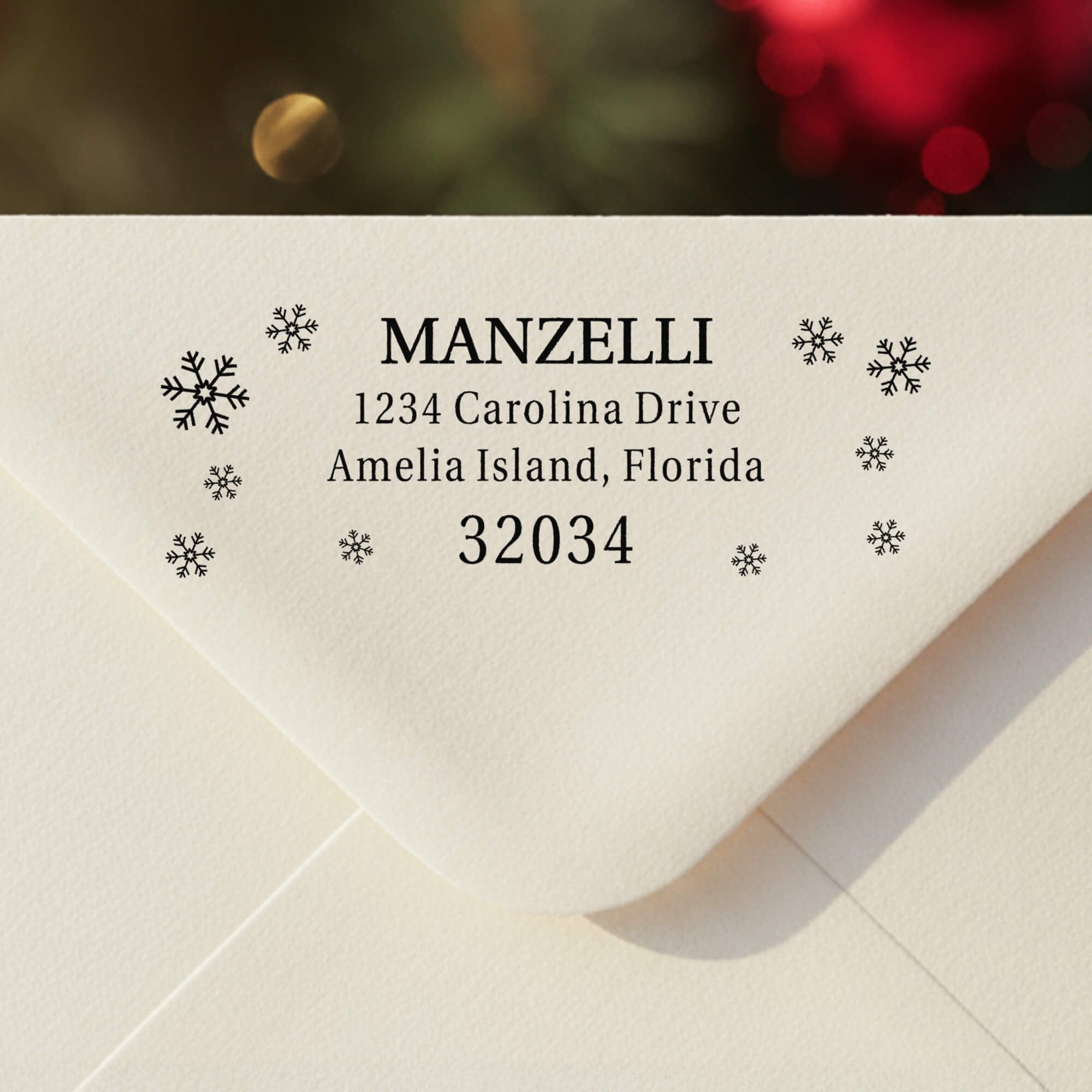 Personalized ‘Manzelli Snowflake’ address stamp impression on envelope flap for holiday cards.