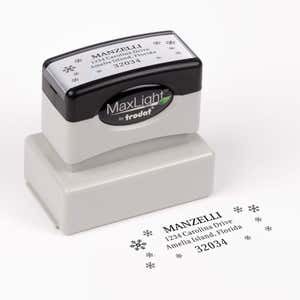 Pre-inked stamp shown from above featuring custom ‘Manzelli Snowflake’  holiday return address design.