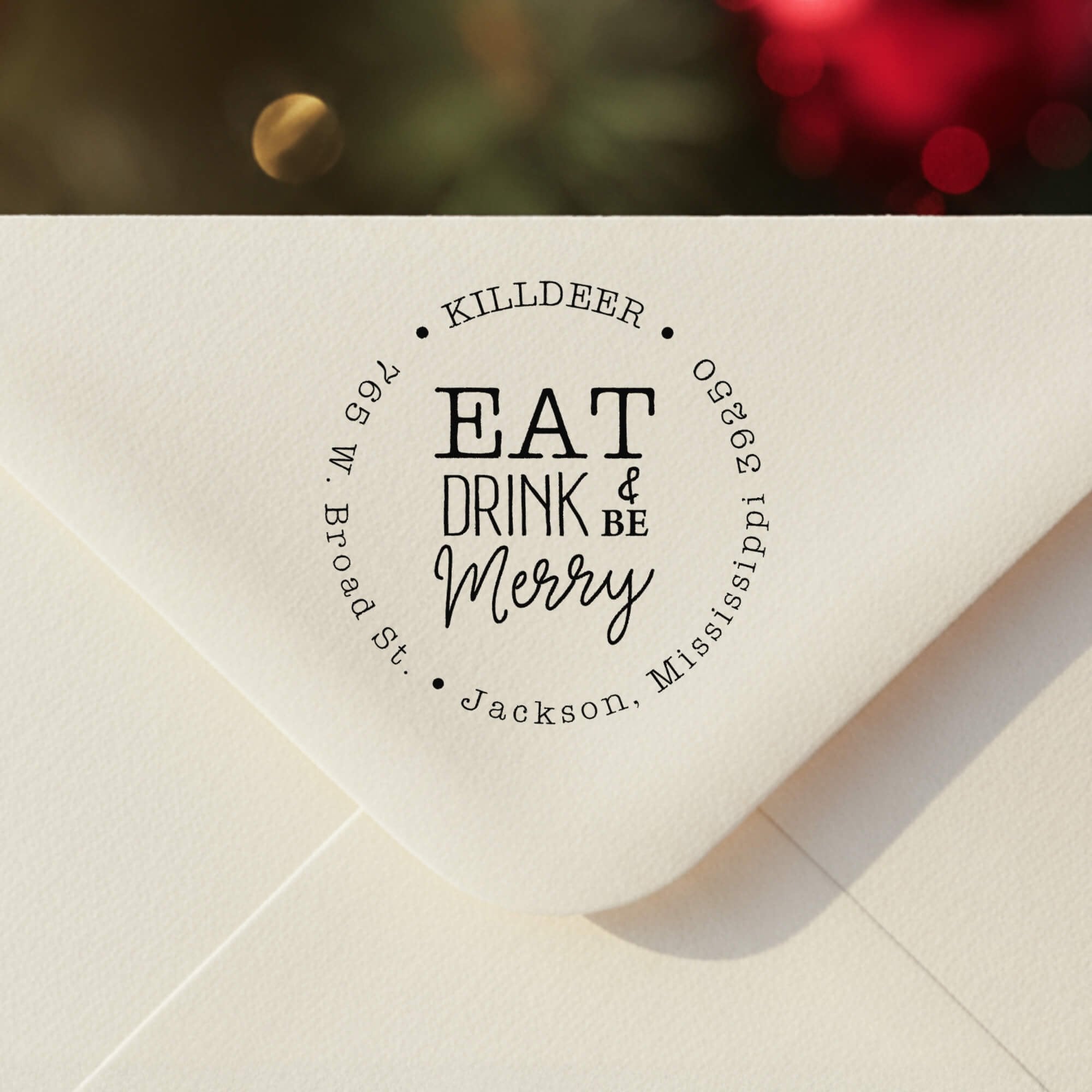 Personalized ‘Eat Drink and Be Merry’ address stamp impression on envelope flap for holiday cards.