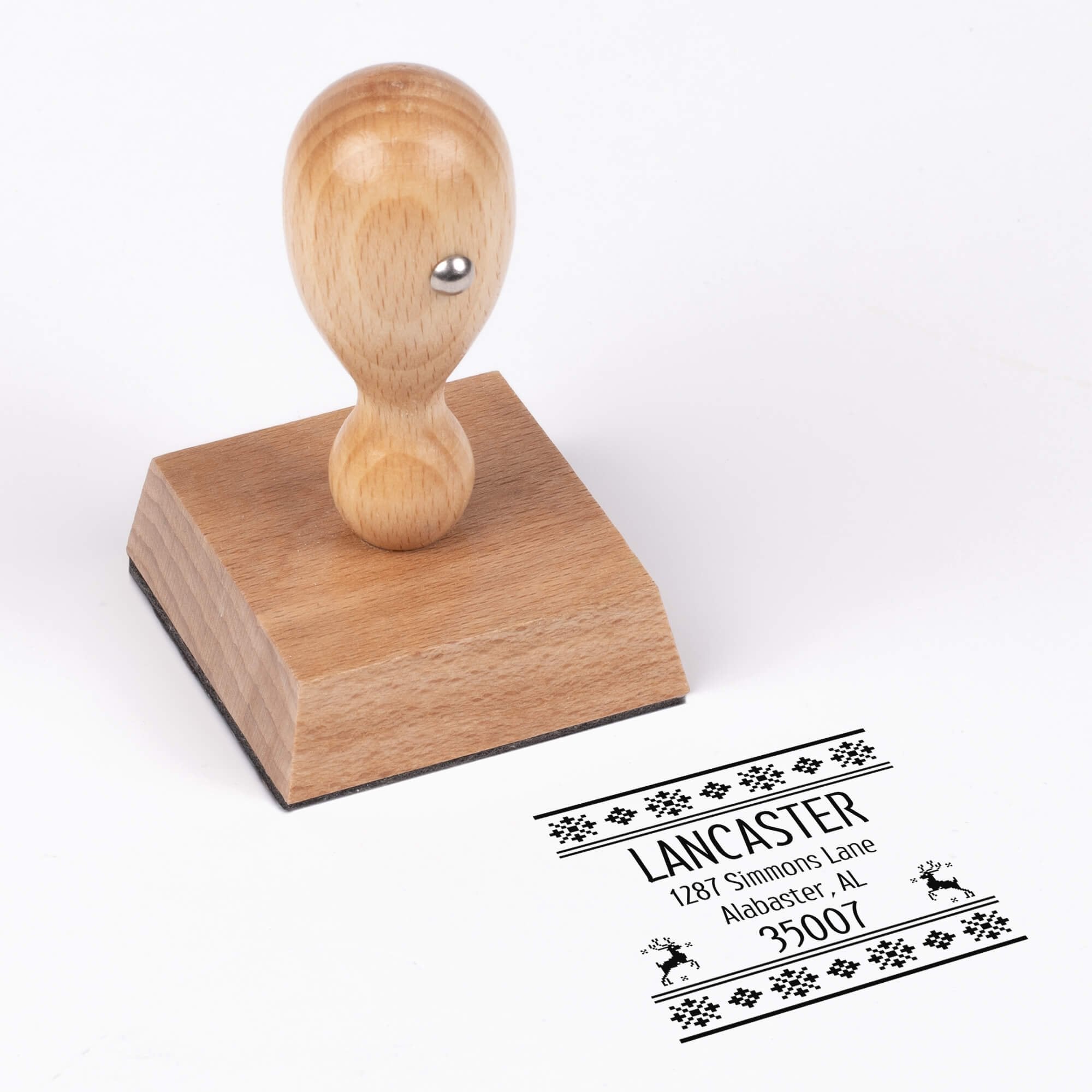 European wood hand stamp shown from above featuring custom ‘Designer Reindeer’ holiday return address design.