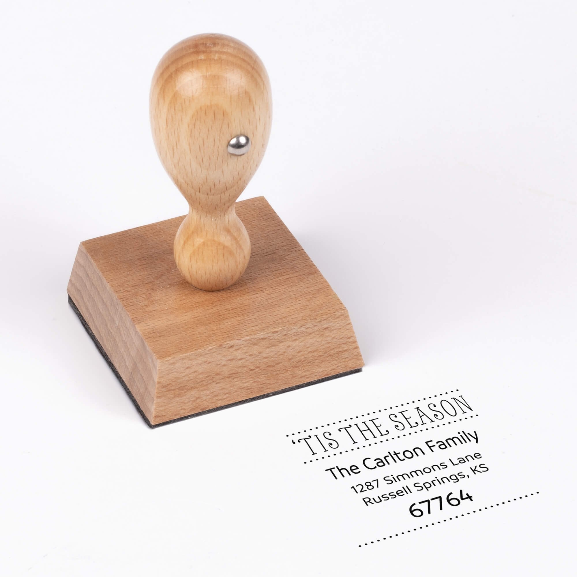 European wood hand stamp shown from above featuring custom ‘Tis The Season’ holiday return address design.