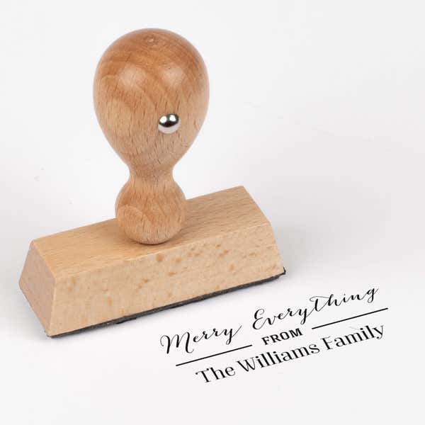 European wood hand stamp shown from above featuring custom ‘Merry Everything’ holiday return address design.