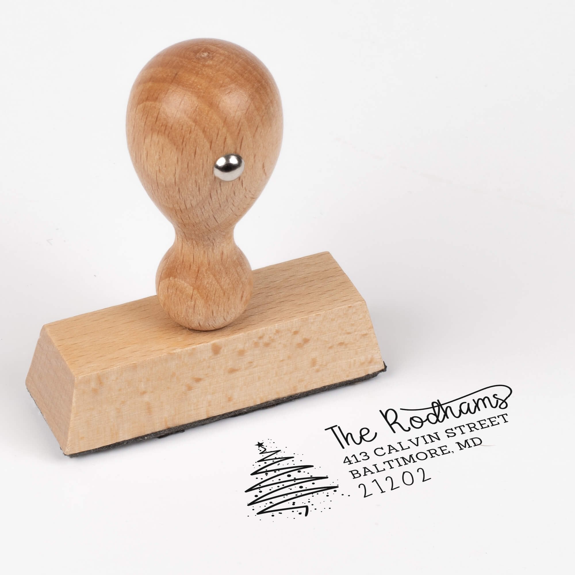 European wood hand stamp shown from above featuring custom ‘Rodham Script Christmas Tree’ holiday return address design.