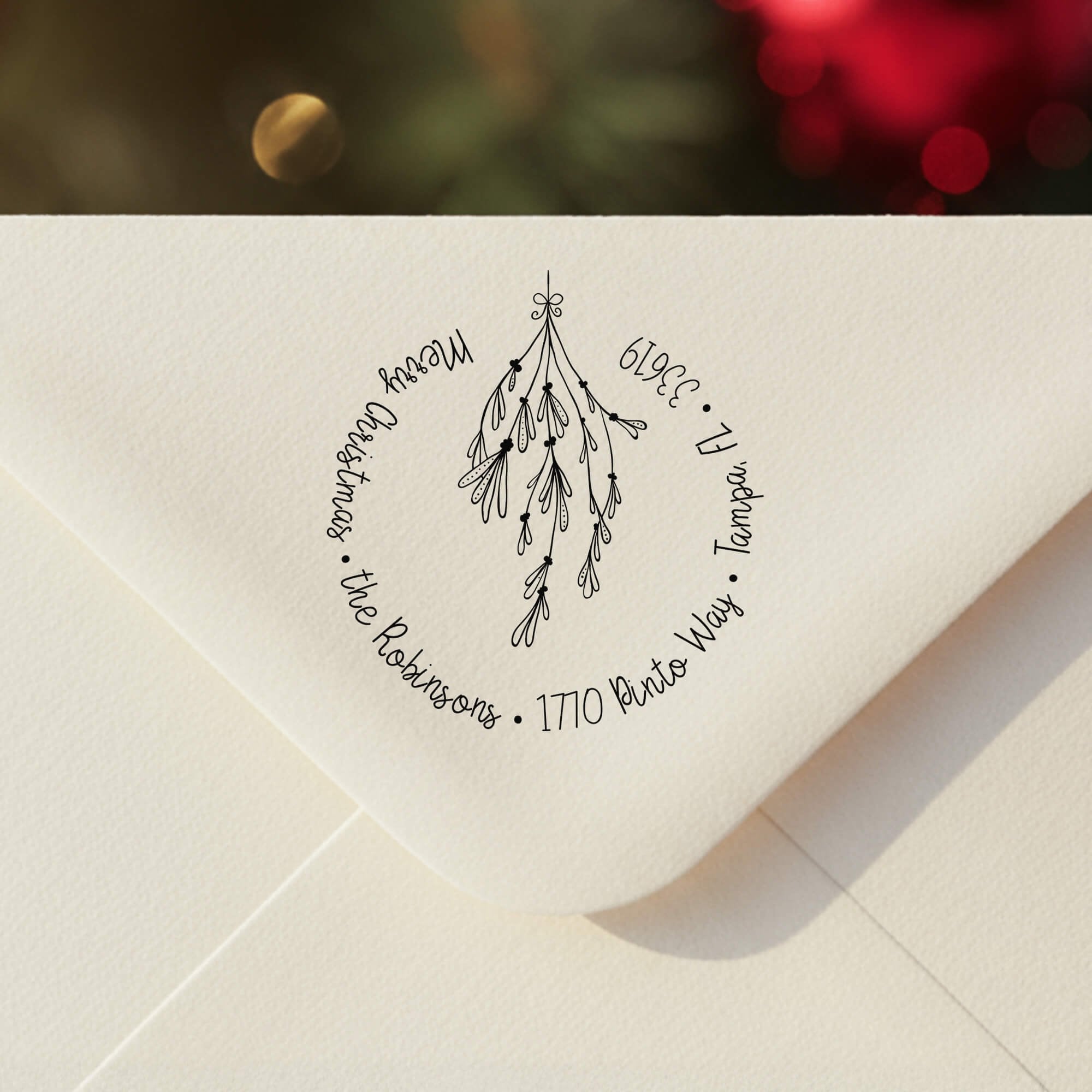 Personalized ‘Mistletoe Round Script’ address stamp impression on envelope flap for holiday cards.