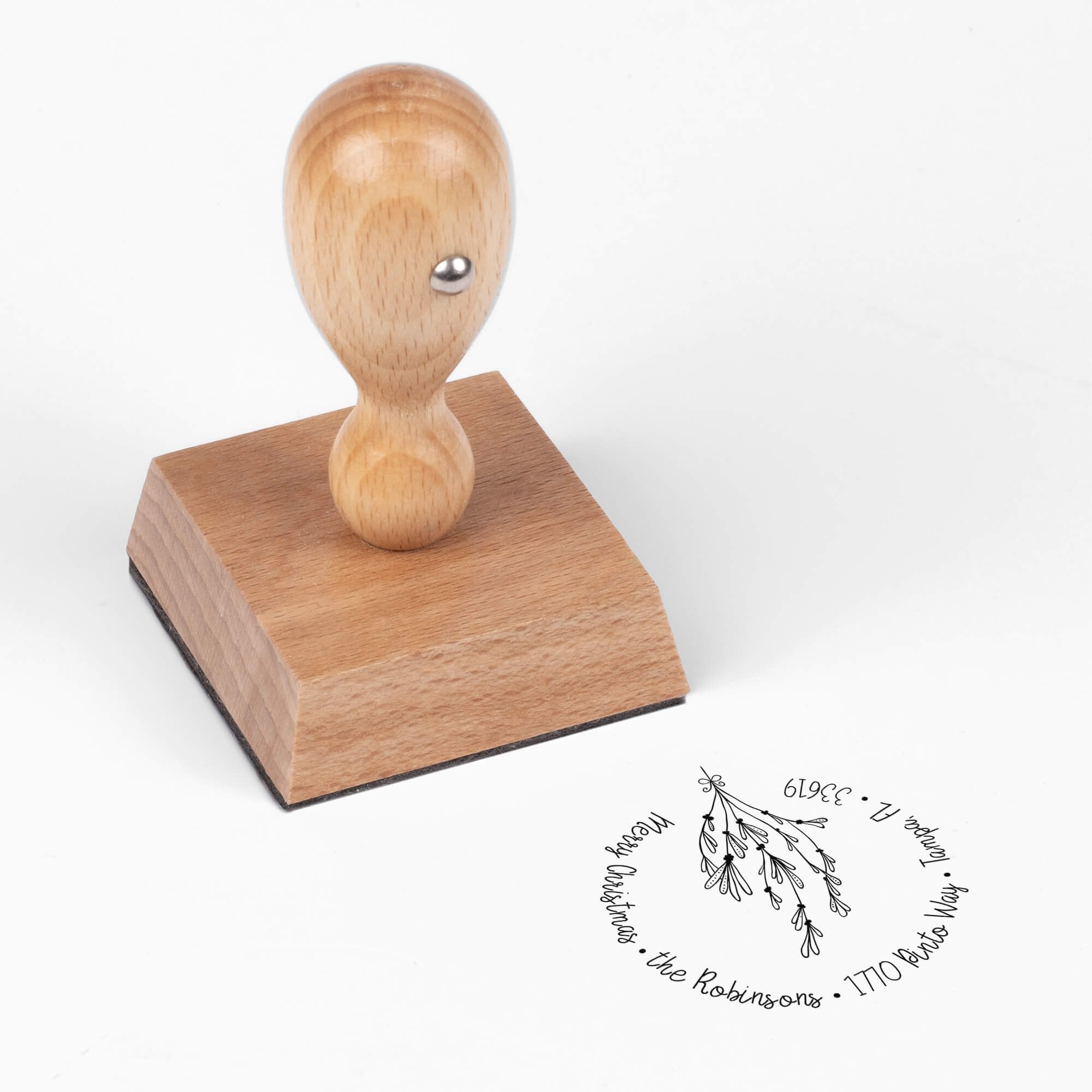 European wood hand stamp shown from above featuring custom ‘Mistletoe Round Script’ holiday return address design.