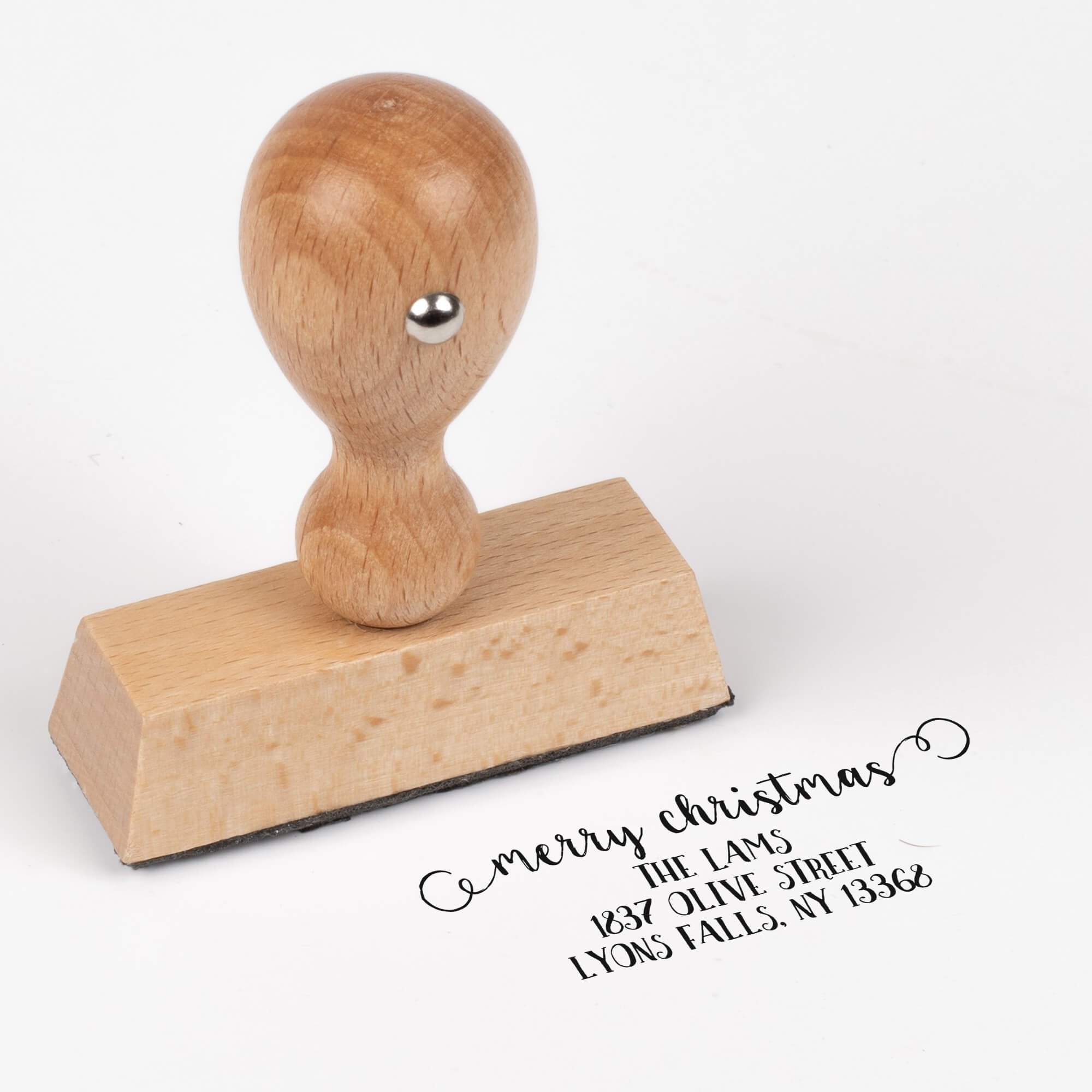 European wood hand stamp shown from above featuring custom ‘Merry Christmas Decorative Swirl’ holiday return address design.
