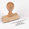 European wood hand stamp shown from above featuring custom ‘Merry Christmas Decorative Swirl’ holiday return address design.