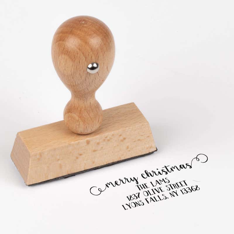 European wood hand stamp shown from above featuring custom ‘Merry Christmas Decorative Swirl’ holiday return address design.