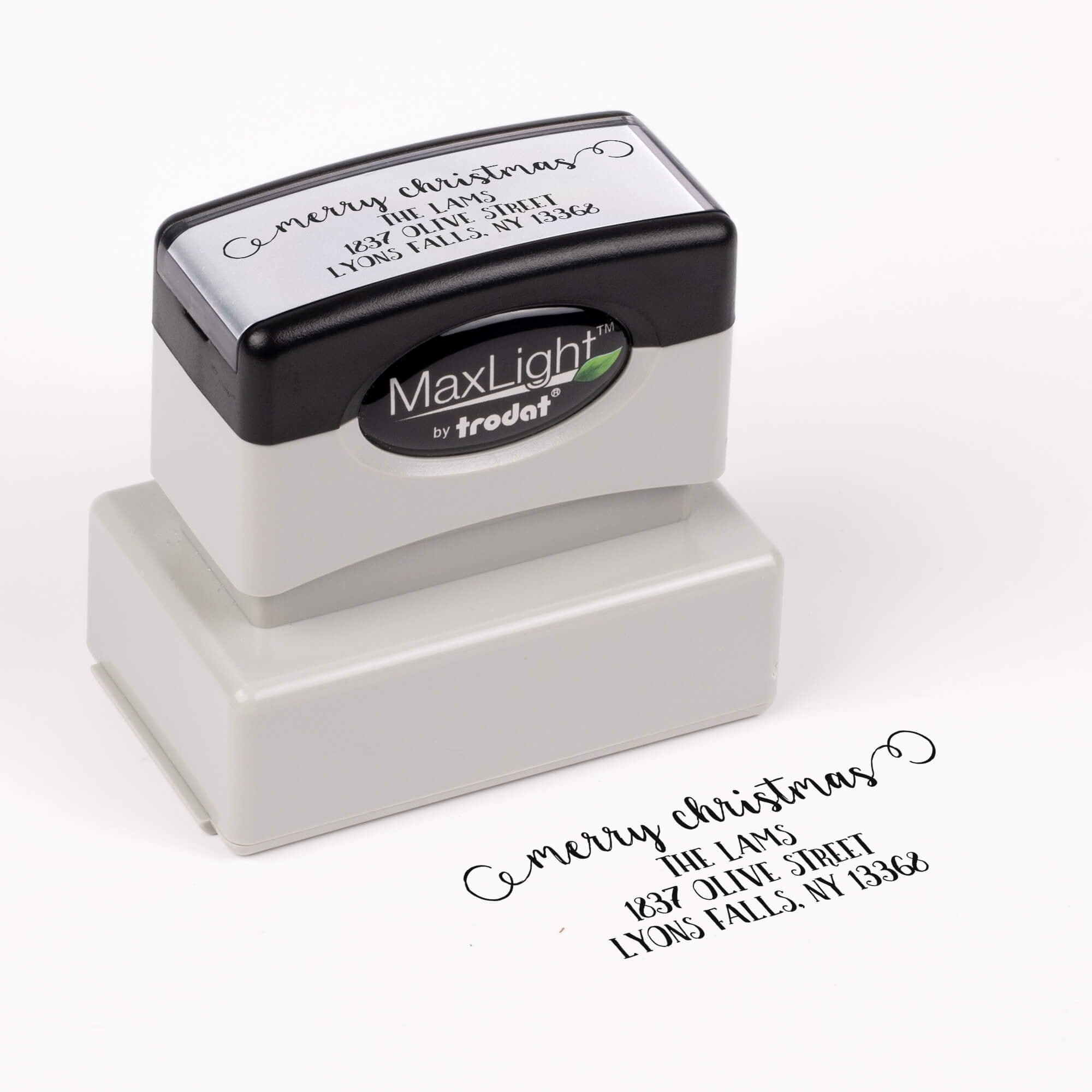 Pre-inked stamp shown from above featuring custom ‘Merry Christmas Decorative Swirl’  holiday return address design.
