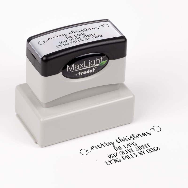 Pre-inked stamp shown from above featuring custom ‘Merry Christmas Decorative Swirl’  holiday return address design.