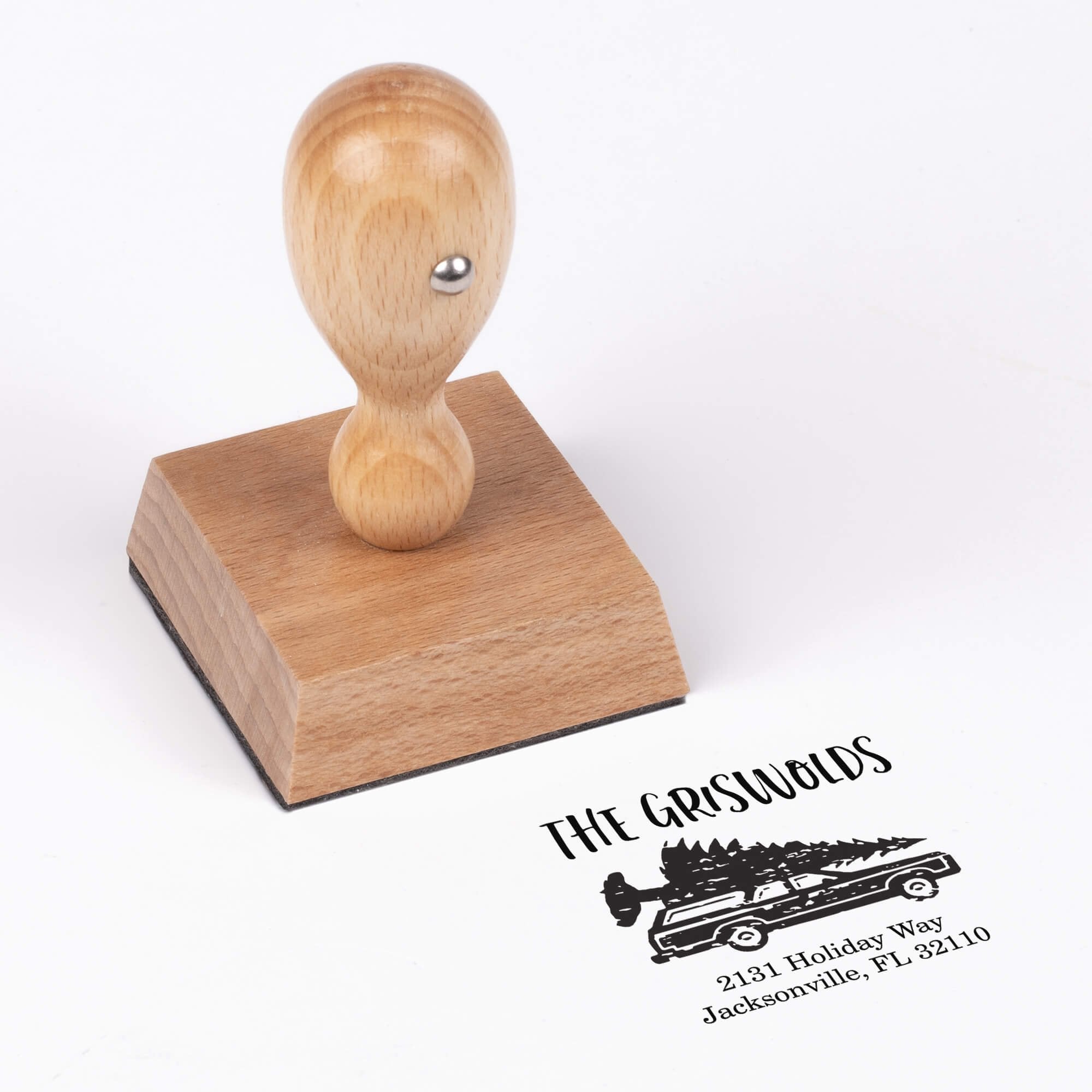 European wood hand stamp shown from above featuring custom ‘Griswold Holiday’ holiday return address design.