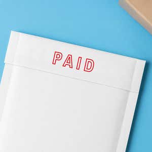Red outline PAID stamped on a white envelope flap, mailroom example