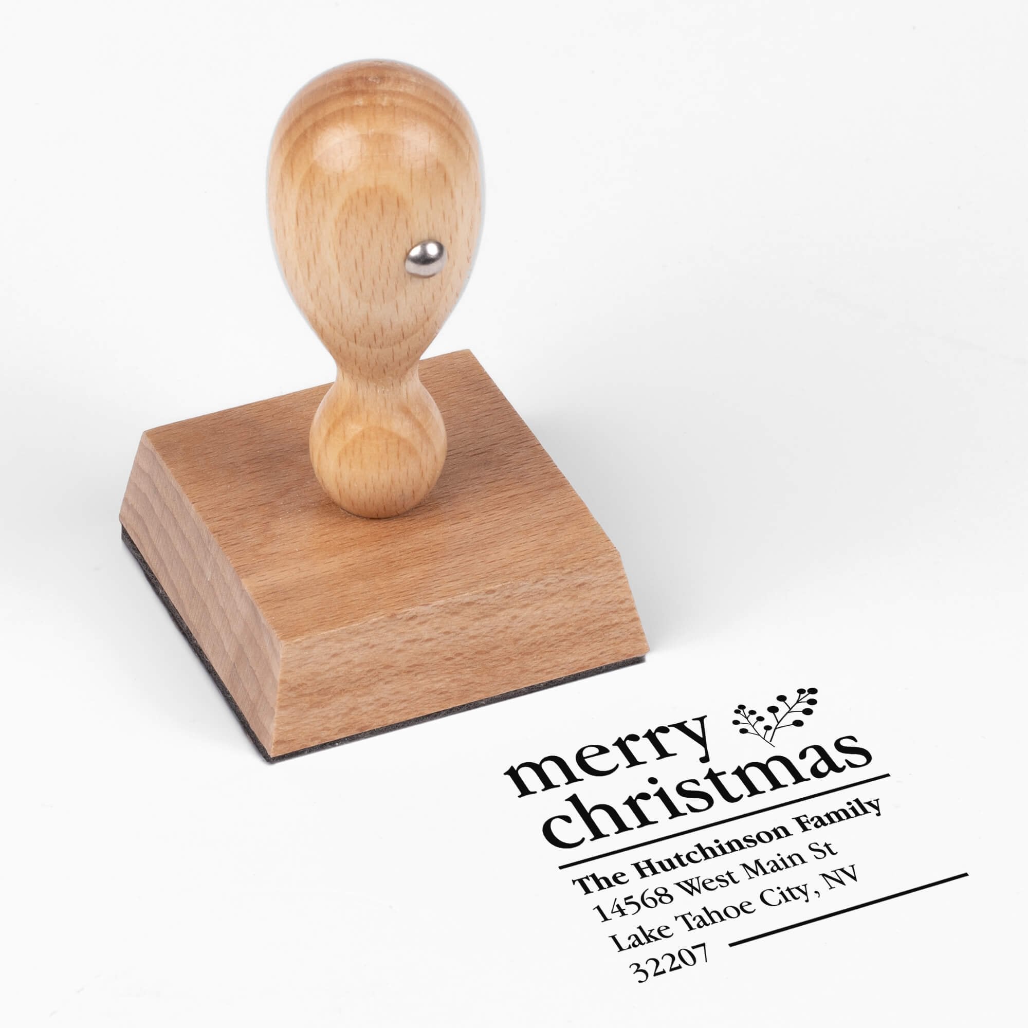 European wood hand stamp shown from above featuring custom ‘Merry Christmas With Fern’ holiday return address design.