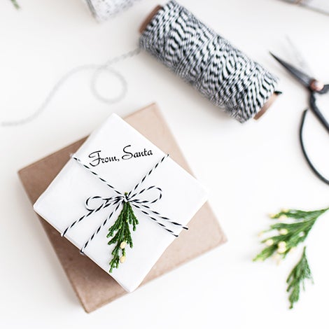 Santa signature stamp on a red gift tag